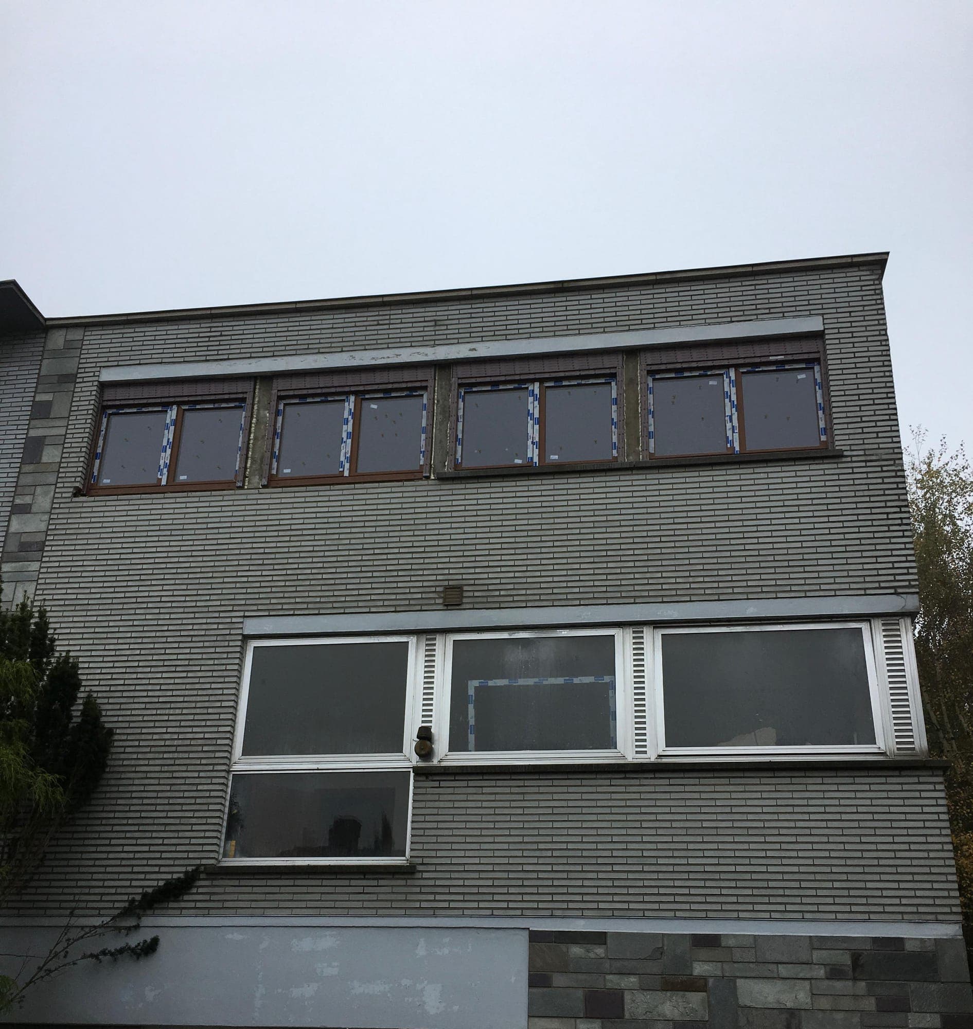 Bandeau de fenêtres neuves sur façade en briques